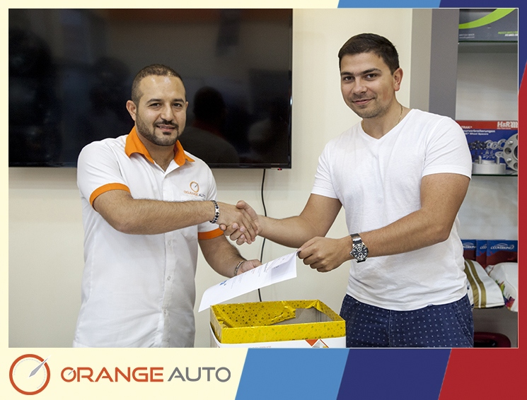 A worker and a client at Orange Auto center UAE